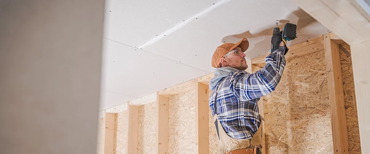 Certified Contractor installing drywalls on ceiling