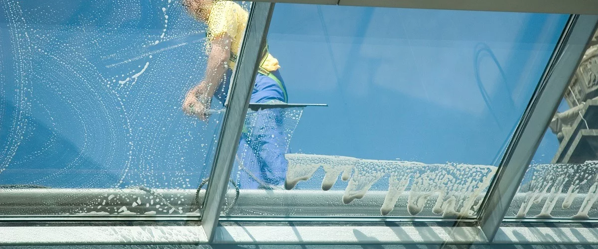 Contractor cleaning window rooftop